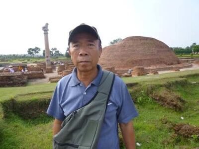 Tác giả Nguyễn Gia Kiểng tại stupa (mộ Phật) ở Vashali, bên trái là cột của vua Asoka với tượng sư tử trên đỉnh.